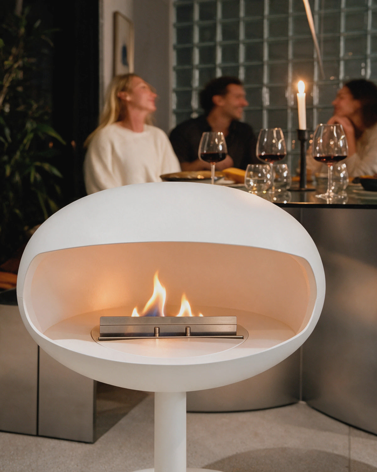 Cheminée bioéthanol Kumo blanc allumée près d'une table lors d'un dîner