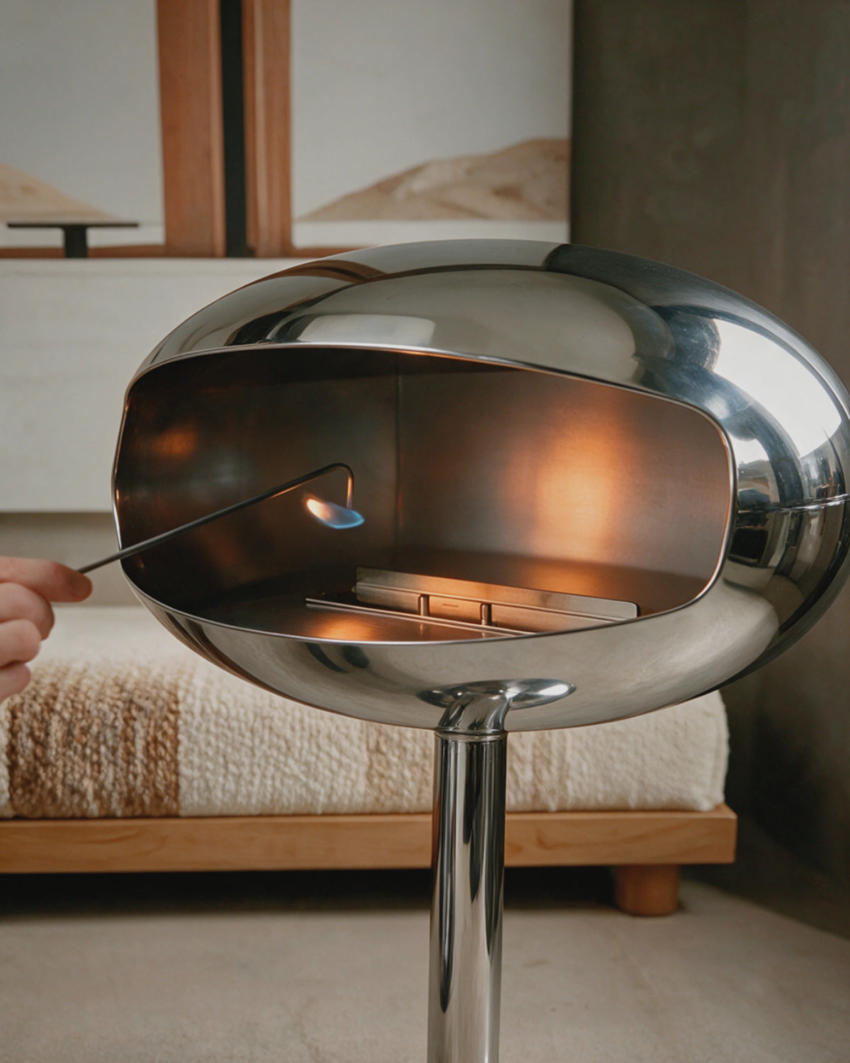 Cheminée bioéthanol Kumo chrome effet miroir allumée dans une chambre